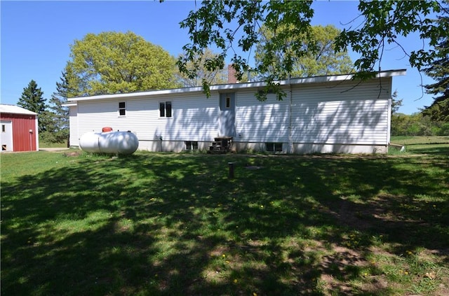 W2585 County Road R, Durand, WI 54736 - back of property featuring a lawn, an outdoor structure, a chimney, and a storage unit