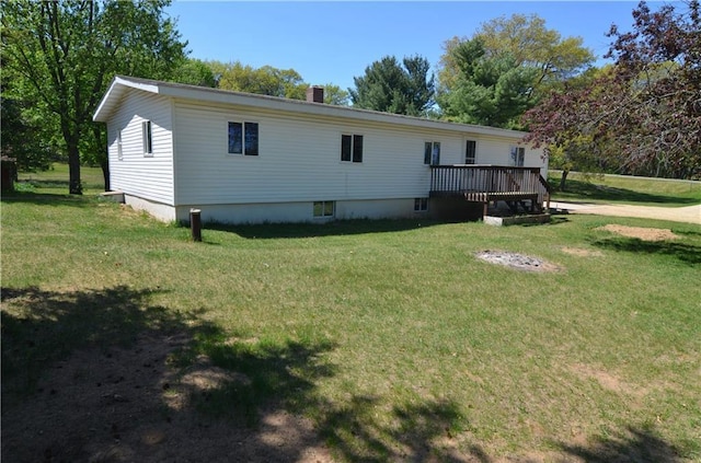 W2585 County Road R, Durand, WI 54736 - back of house featuring a lawn, a wooden deck, and a chimney