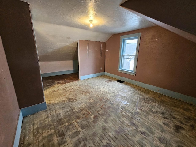 308 W Prospect St, Endeavor, WI 53930 - bonus room featuring lofted ceiling, a textured ceiling, wood-type flooring, and baseboards