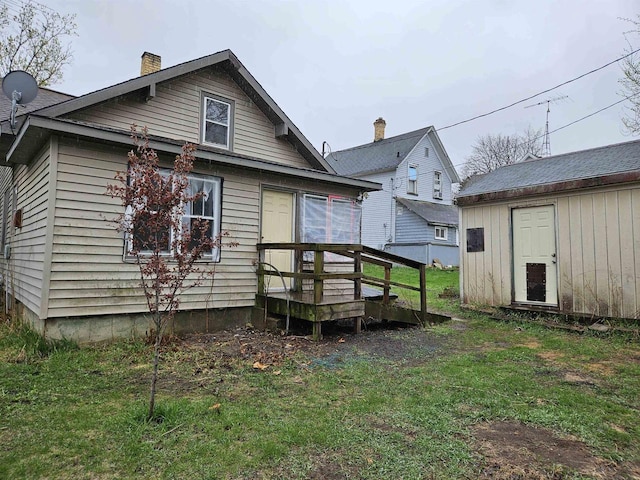 308 W Prospect St, Endeavor, WI 53930 - rear view of property featuring a chimney, a lawn, an outbuilding, and a wooden deck