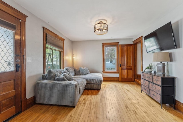 610 W Franklin St, Portage, WI 53901 - living area with light wood-type flooring, a chandelier, and baseboards
