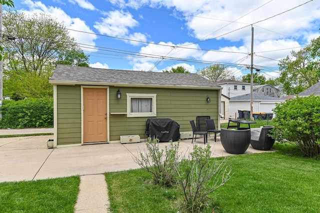 2377 S 73rd St, West Allis, WI 53219 - back of property featuring a patio area, a lawn, and an outbuilding