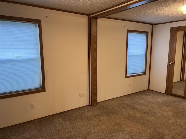 carpeted empty room with a textured ceiling