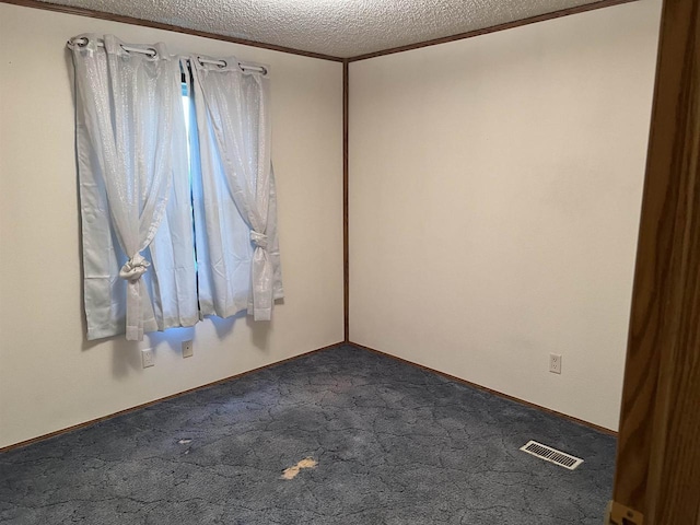 unfurnished room with a textured ceiling and dark carpet