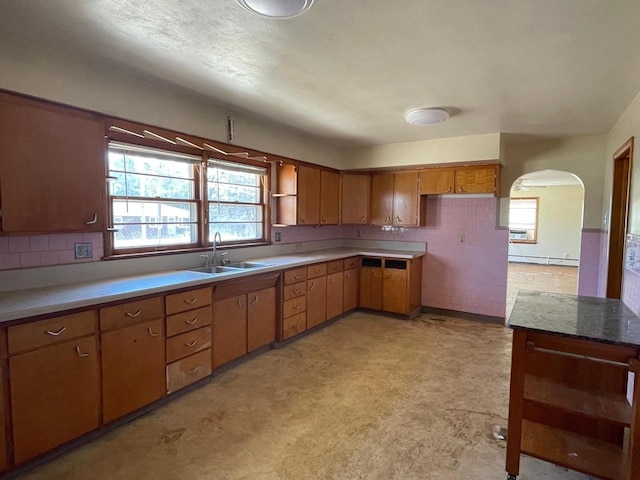 1546-15461/2 Garfield Ave, Beloit, WI 53511 - kitchen featuring a sink, a baseboard heating unit, open shelves, arched walkways, and light countertops