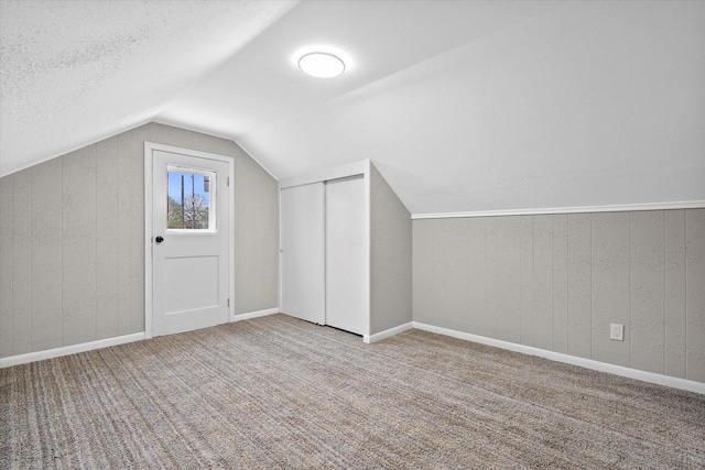 1143 S 23rd St, Manitowoc, WI 54220 - additional living space featuring lofted ceiling, carpet flooring, and a textured ceiling