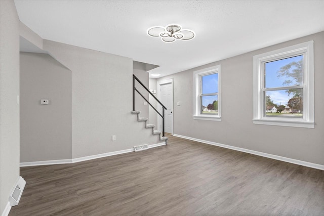 1143 S 23rd St, Manitowoc, WI 54220 - unfurnished living room featuring wood finished floors, stairs, and baseboards