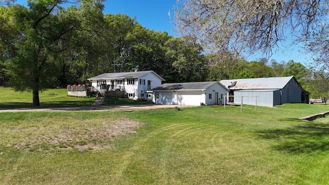 18051 Ideal Rd, Sparta, WI 54656 - view of front facade featuring a deck, a front yard, an outbuilding, and a pole building
