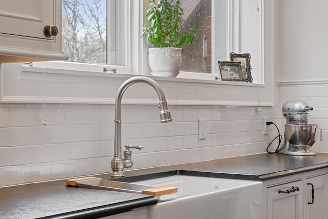 2663 N Wahl Ave, Milwaukee, WI 53211 - kitchen featuring a sink, dark countertops, white cabinets, and decorative backsplash