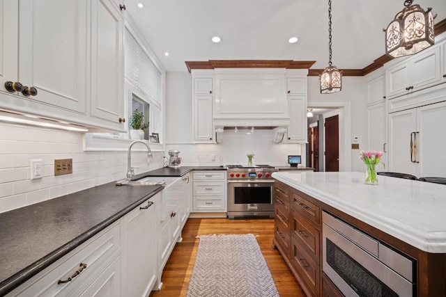 2663 N Wahl Ave, Milwaukee, WI 53211 - kitchen featuring stainless steel appliances, a sink, recessed lighting, white cabinets, and backsplash