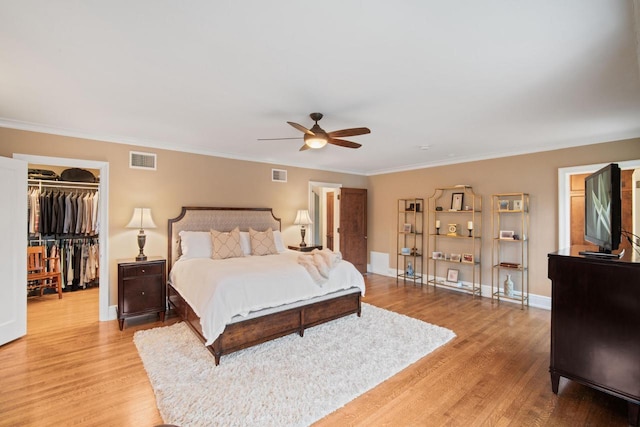 2663 N Wahl Ave, Milwaukee, WI 53211 - bedroom with light wood-style floors, a walk in closet, baseboards, crown molding, and a closet