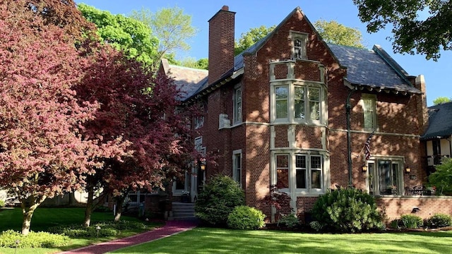 2663 N Wahl Ave, Milwaukee, WI 53211 - view of property exterior with a chimney, brick siding, a lawn, and a high end roof