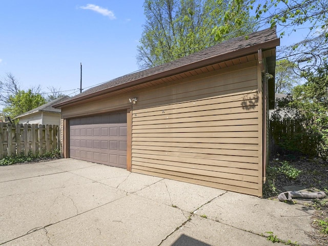 detached garage featuring fence