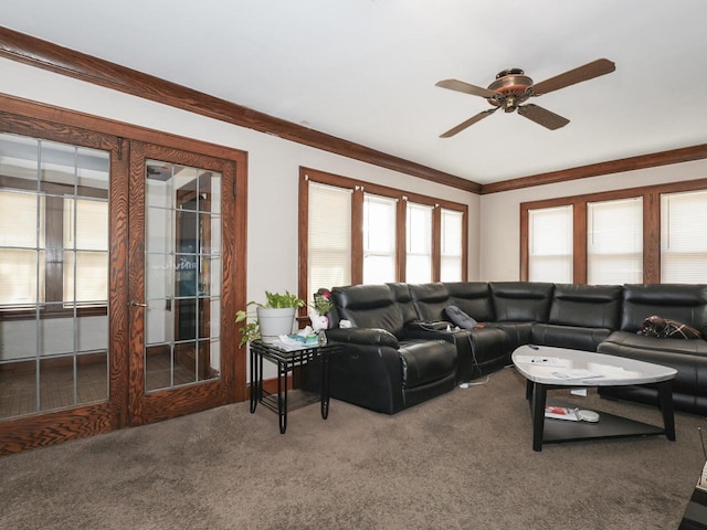 living room with a ceiling fan, carpet floors, and ornamental molding