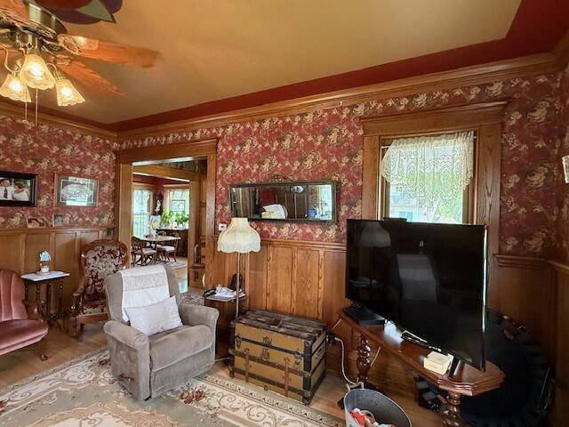 400 S Water St, Sparta, WI 54656 - living room with plenty of natural light, ceiling fan, a wainscoted wall, wallpapered walls, and wood finished floors