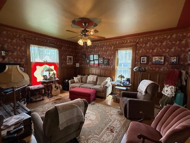 400 S Water St, Sparta, WI 54656 - living area with wallpapered walls, ceiling fan, plenty of natural light, crown molding, and wood finished floors
