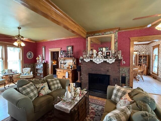 400 S Water St, Sparta, WI 54656 - living room with a ceiling fan, a brick fireplace, beamed ceiling, wallpapered walls, and wood finished floors