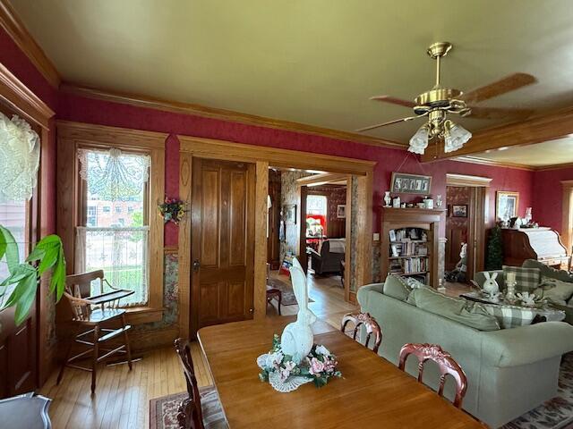 400 S Water St, Sparta, WI 54656 - dining room featuring a ceiling fan, hardwood / wood-style floors, crown molding, and a fireplace