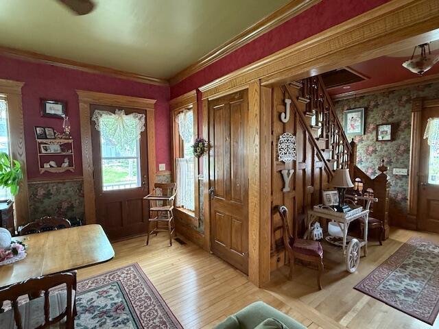 400 S Water St, Sparta, WI 54656 - foyer entrance with stairs, wallpapered walls, wood finished floors, and crown molding