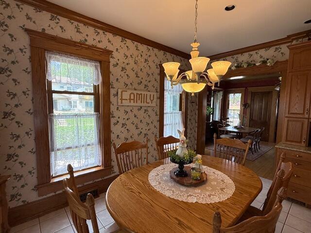 400 S Water St, Sparta, WI 54656 - dining room featuring wallpapered walls, light tile patterned floors, a chandelier, crown molding, and healthy amount of natural light