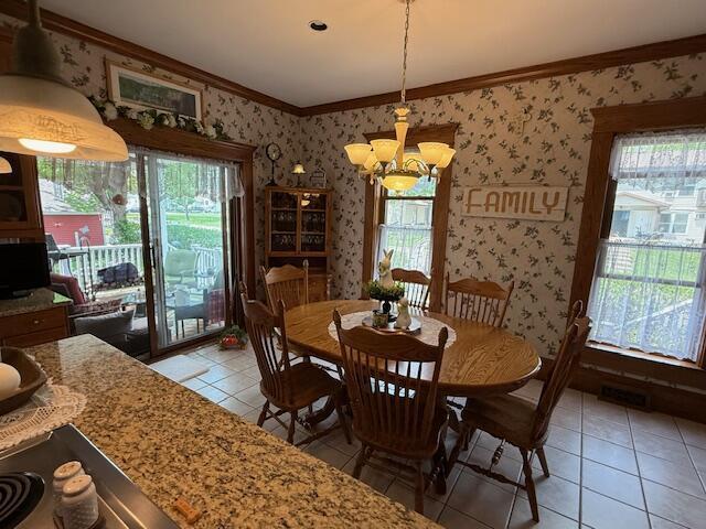 400 S Water St, Sparta, WI 54656 - dining space featuring ornamental molding, wallpapered walls, light tile patterned floors, a chandelier, and healthy amount of natural light