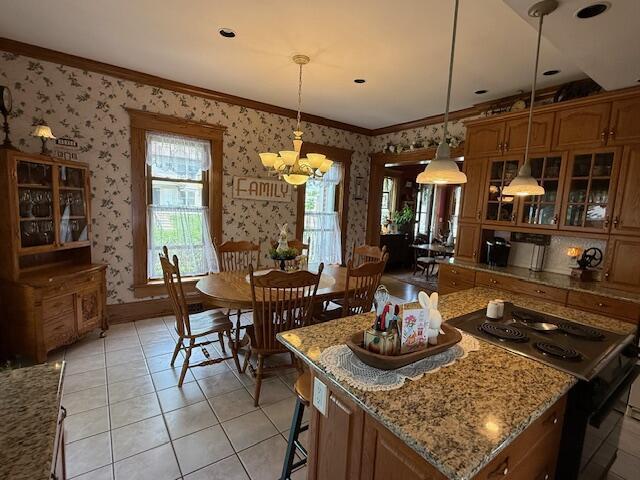400 S Water St, Sparta, WI 54656 - kitchen with wallpapered walls, electric range, a chandelier, glass insert cabinets, and ornamental molding
