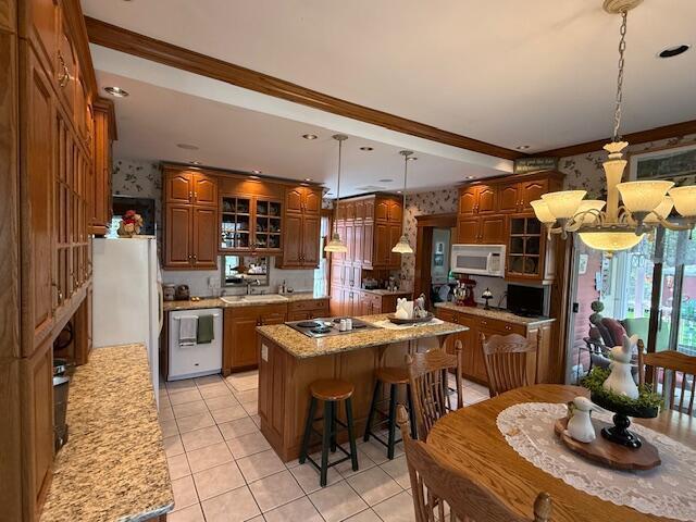 400 S Water St, Sparta, WI 54656 - kitchen featuring dishwashing machine, white microwave, wallpapered walls, stainless steel stovetop, and glass insert cabinets