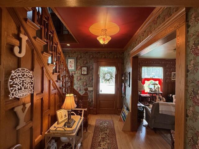 400 S Water St, Sparta, WI 54656 - foyer featuring wallpapered walls, light wood-style floors, ornamental molding, and stairs