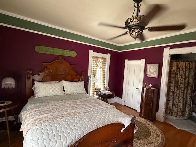 400 S Water St, Sparta, WI 54656 - bedroom featuring wood finished floors, crown molding, baseboards, and ceiling fan