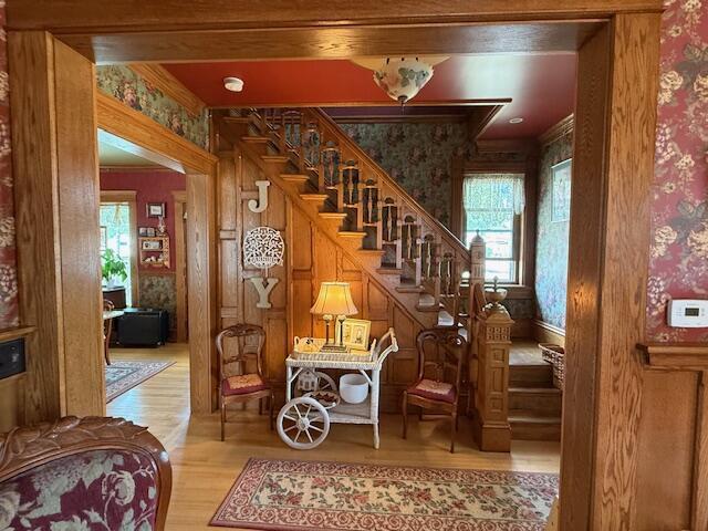400 S Water St, Sparta, WI 54656 - stairs featuring wallpapered walls, wood finished floors, and crown molding