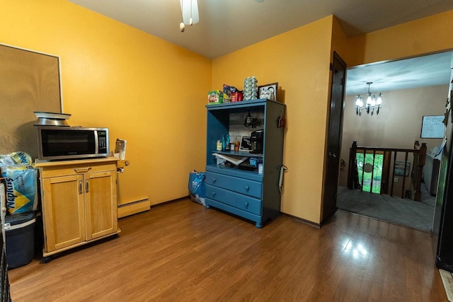 105 Glenview Dr, Tomah, WI 54660 - kitchen featuring stainless steel microwave, light wood-style flooring, a baseboard heating unit, a chandelier, and a ceiling fan
