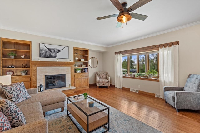 4531 Tabor Rd, Racine, WI 53402 - living room featuring crown molding, ceiling fan, baseboards, hardwood / wood-style floors, and a tile fireplace