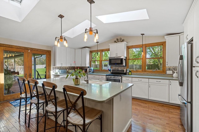 4531 Tabor Rd, Racine, WI 53402 - kitchen with appliances with stainless steel finishes, a skylight, backsplash, a sink, and lofted ceiling