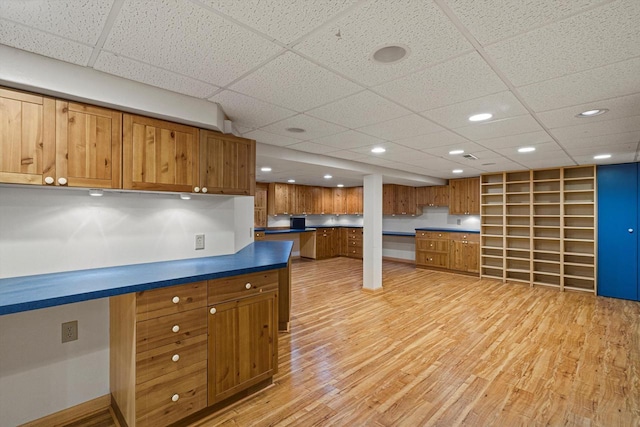 4531 Tabor Rd, Racine, WI 53402 - kitchen with brown cabinetry, a paneled ceiling, light wood-type flooring, dark countertops, and recessed lighting