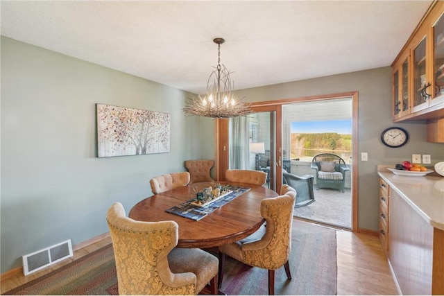 2929 170th St, Frederic, WI 54837 - dining space featuring a chandelier, light wood-style floors, and baseboards