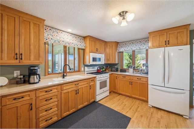 2929 170th St, Frederic, WI 54837 - kitchen with white appliances, a sink, light countertops, light wood-style floors, and a textured ceiling