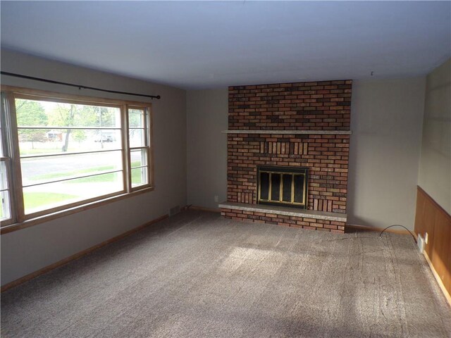 3212 Venus Ave, Eau Claire, WI 54703 - unfurnished living room featuring carpet floors, a brick fireplace, and baseboards