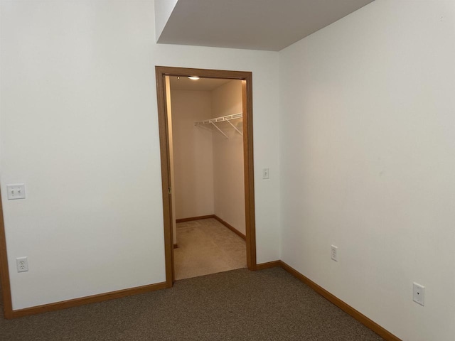 301 Harbour Town Dr Unit 227, Madison, WI 53717 - unfurnished bedroom with a walk in closet, carpet floors, a closet, and baseboards