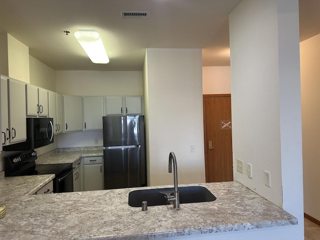 301 Harbour Town Dr Unit 227, Madison, WI 53717 - kitchen featuring black appliances, a sink, and light countertops