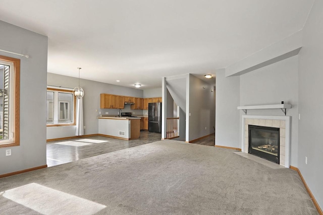 4669 S Forest Point Blvd, New Berlin, WI 53151 - unfurnished living room featuring baseboards, carpet flooring, and a tiled fireplace