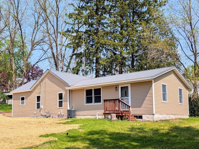 73 Church St, Montello, WI 53949 - view of front facade with central air condition unit, metal roof, and a front yard