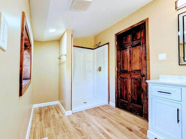 73 Church St, Montello, WI 53949 - full bath featuring wood finished floors, walk in shower, baseboards, vanity, and recessed lighting