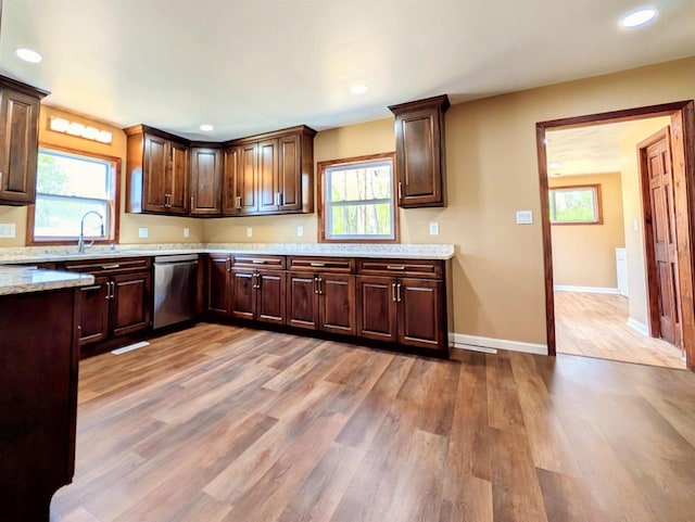 73 Church St, Montello, WI 53949 - kitchen featuring dishwasher, a sink, light wood-type flooring, dark brown cabinetry, and baseboards