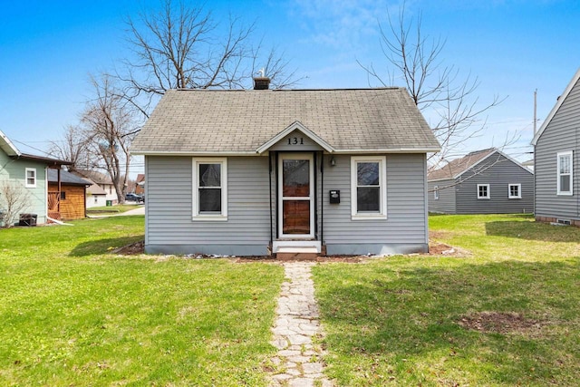 131 S Sidney St, Kimberly, WI 54136 - view of front of house with a front lawn, a shingled roof, and a chimney