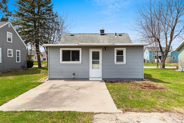 131 S Sidney St, Kimberly, WI 54136 - back of house featuring a patio area, a chimney, a shingled roof, and a lawn