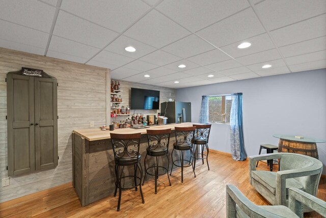 1500 Wolf Dr, West Bend, WI 53090 - indoor dry bar featuring stainless steel fridge with ice dispenser, light wood-type flooring, a drop ceiling, recessed lighting, and baseboards
