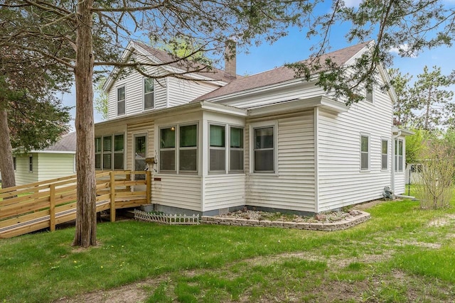407 E Franklin St, Portage, WI 53901 - view of side of property featuring a wooden deck, a lawn, a shingled roof, and a chimney
