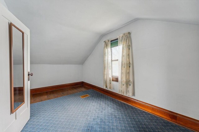 407 E Franklin St, Portage, WI 53901 - additional living space with vaulted ceiling, wood finished floors, and baseboards