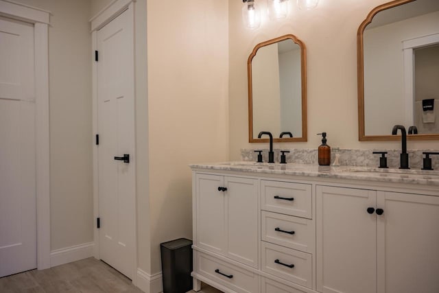 W5613 37th St, New Lisbon, WI 53950 - bathroom featuring wood finished floors, double vanity, and baseboards