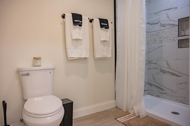 W5613 37th St, New Lisbon, WI 53950 - bathroom featuring a shower stall, toilet, baseboards, and wood finished floors